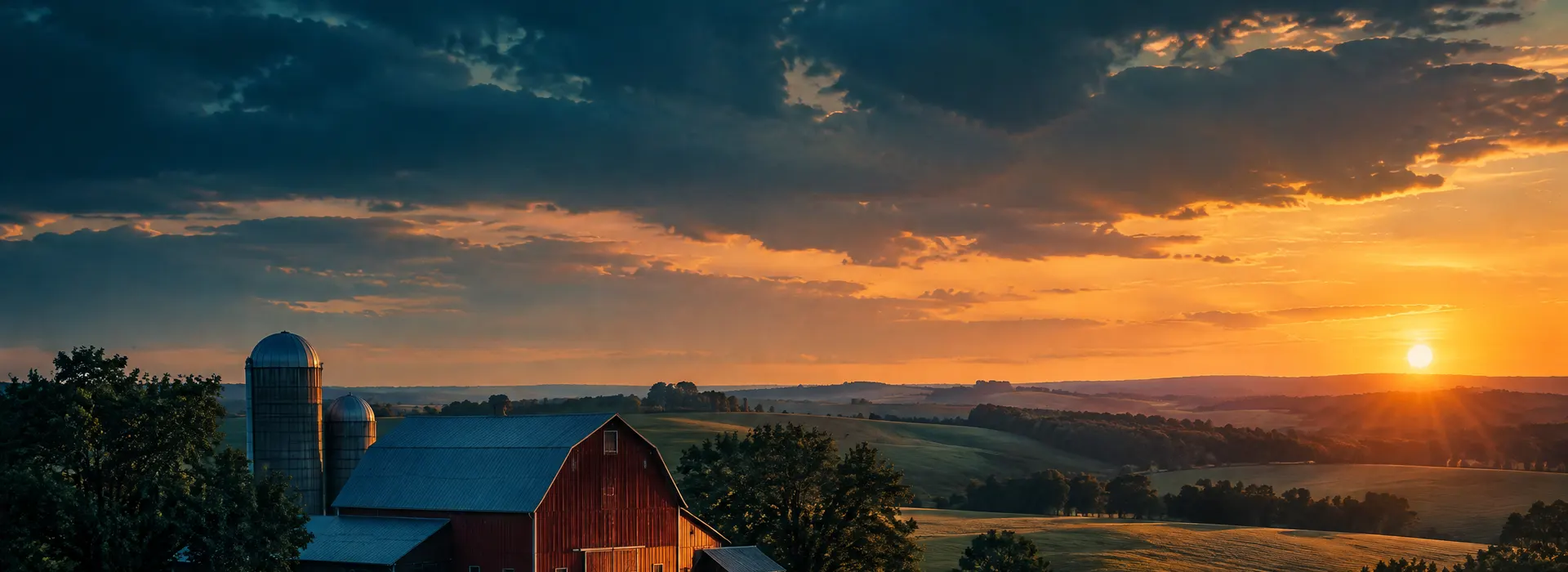 Rolling farmland and a red barn at golden hour in Clinton County, Iowa